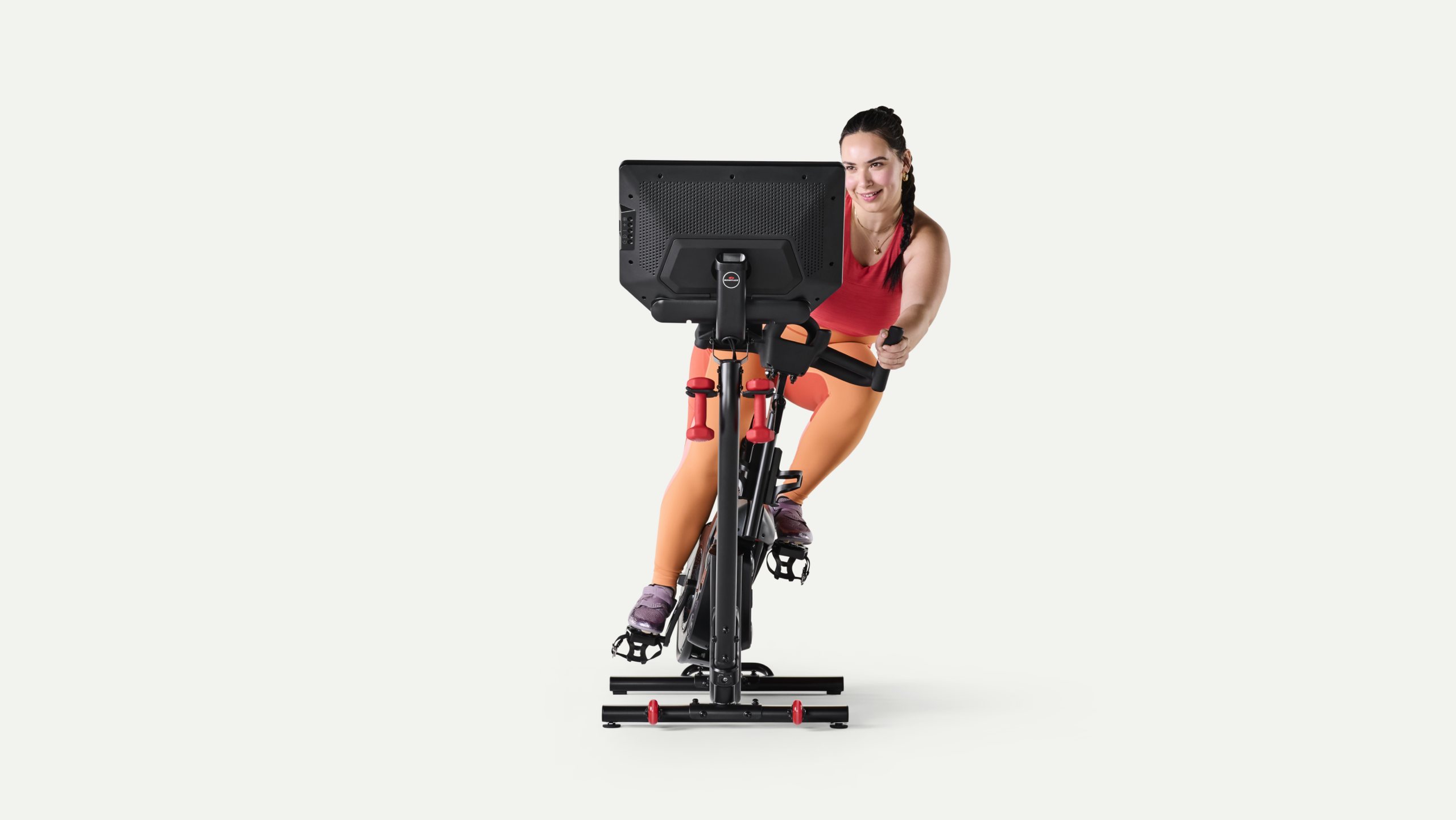 A rider leans a VeloCore to one side while pedalling, seen from the front