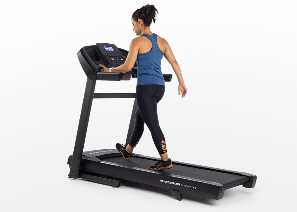 A woman walking on the Horizon T202 with her hand on the console
